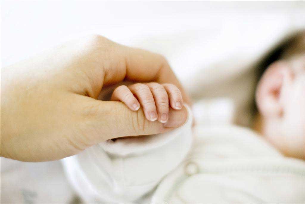 finger holding baby hand